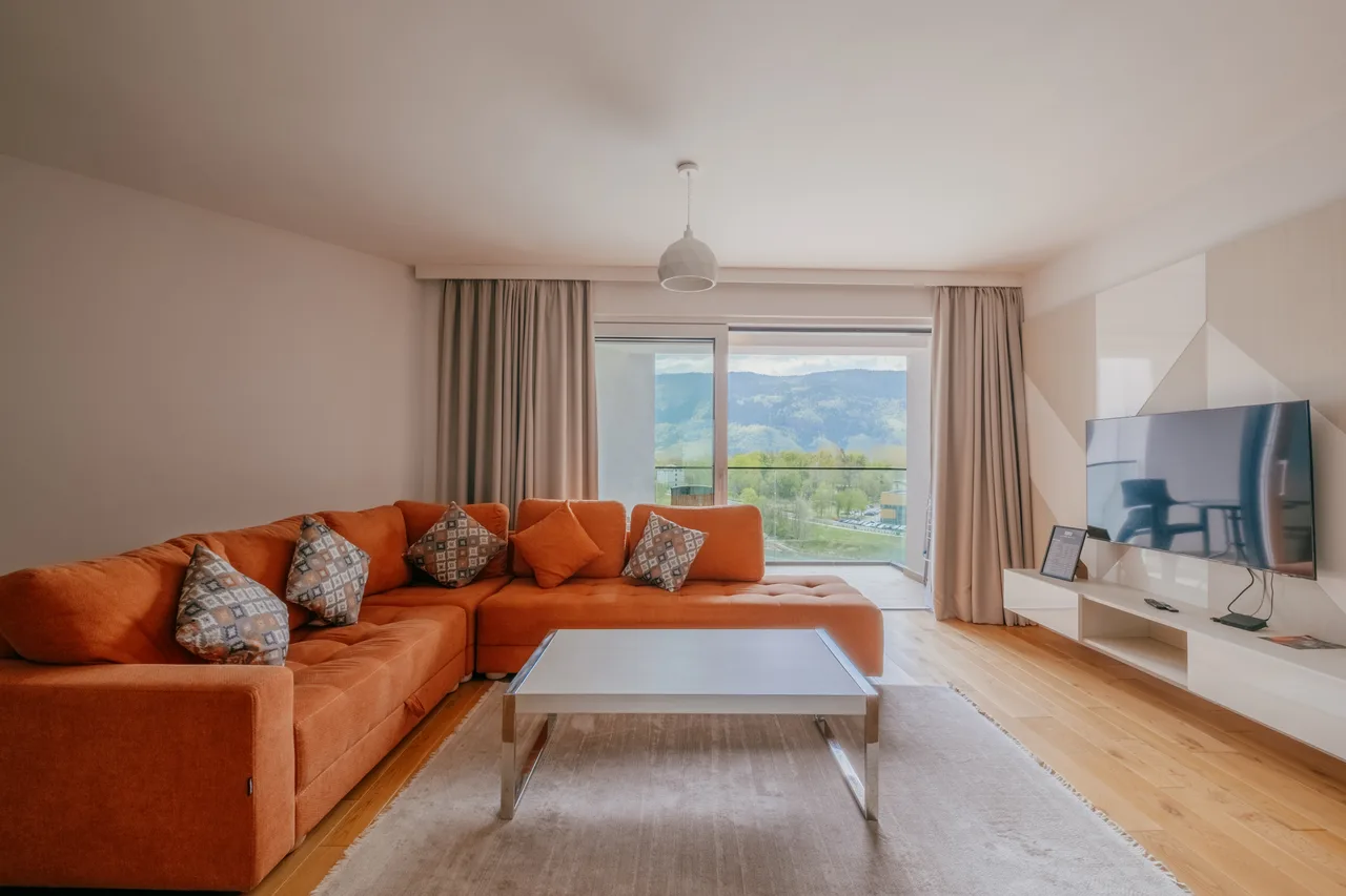 Orange sofa and open kitchen in a one-bedroom apartment