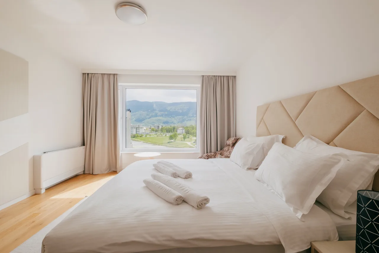 Bedroom — One-bedroom apartment. Orange sofa and cream kitchen