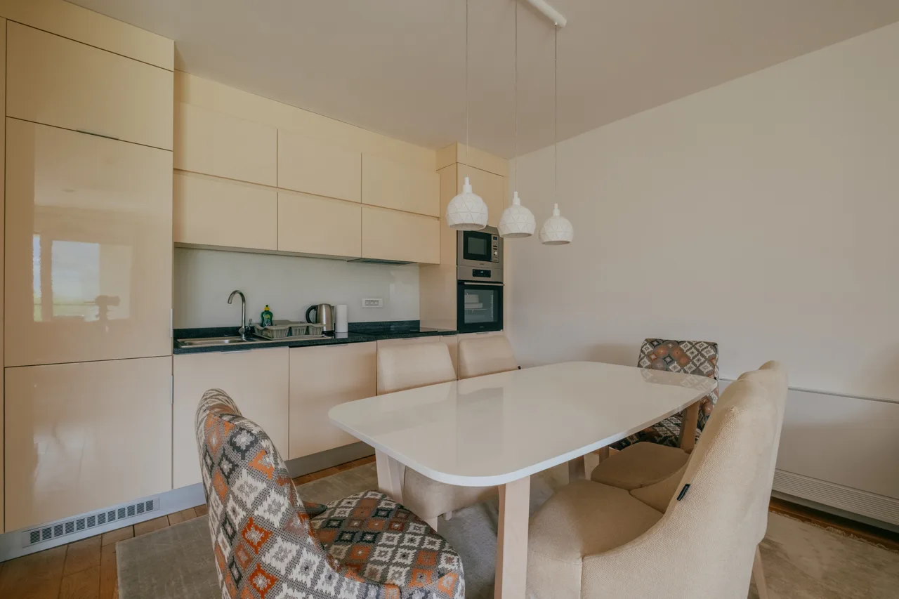 Private apartment kitchen with dining table and cream cabinets