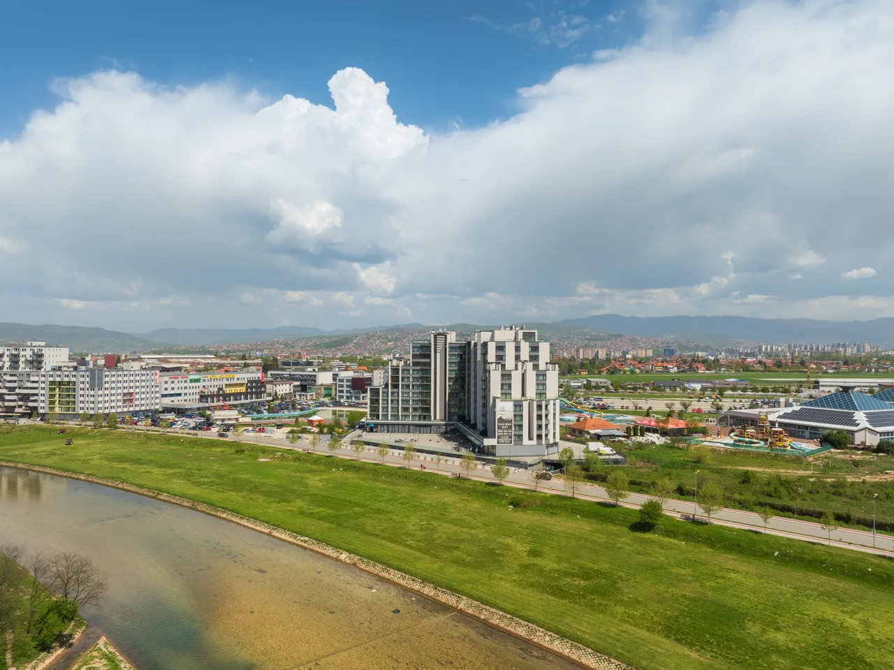 River Walk building beside the river, with Ilidža and the mountains beyond