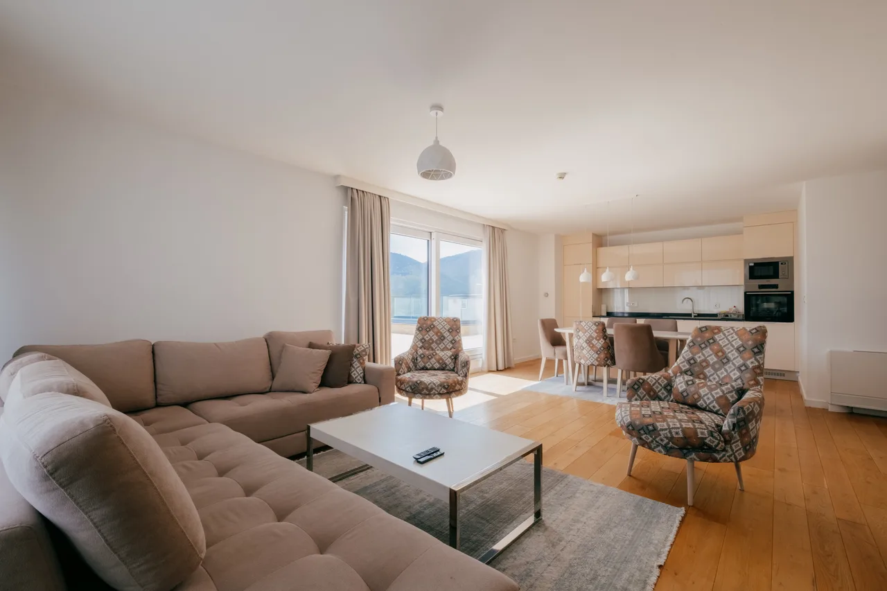 Three-bedroom apartment living room with beige sofa and terrace doors