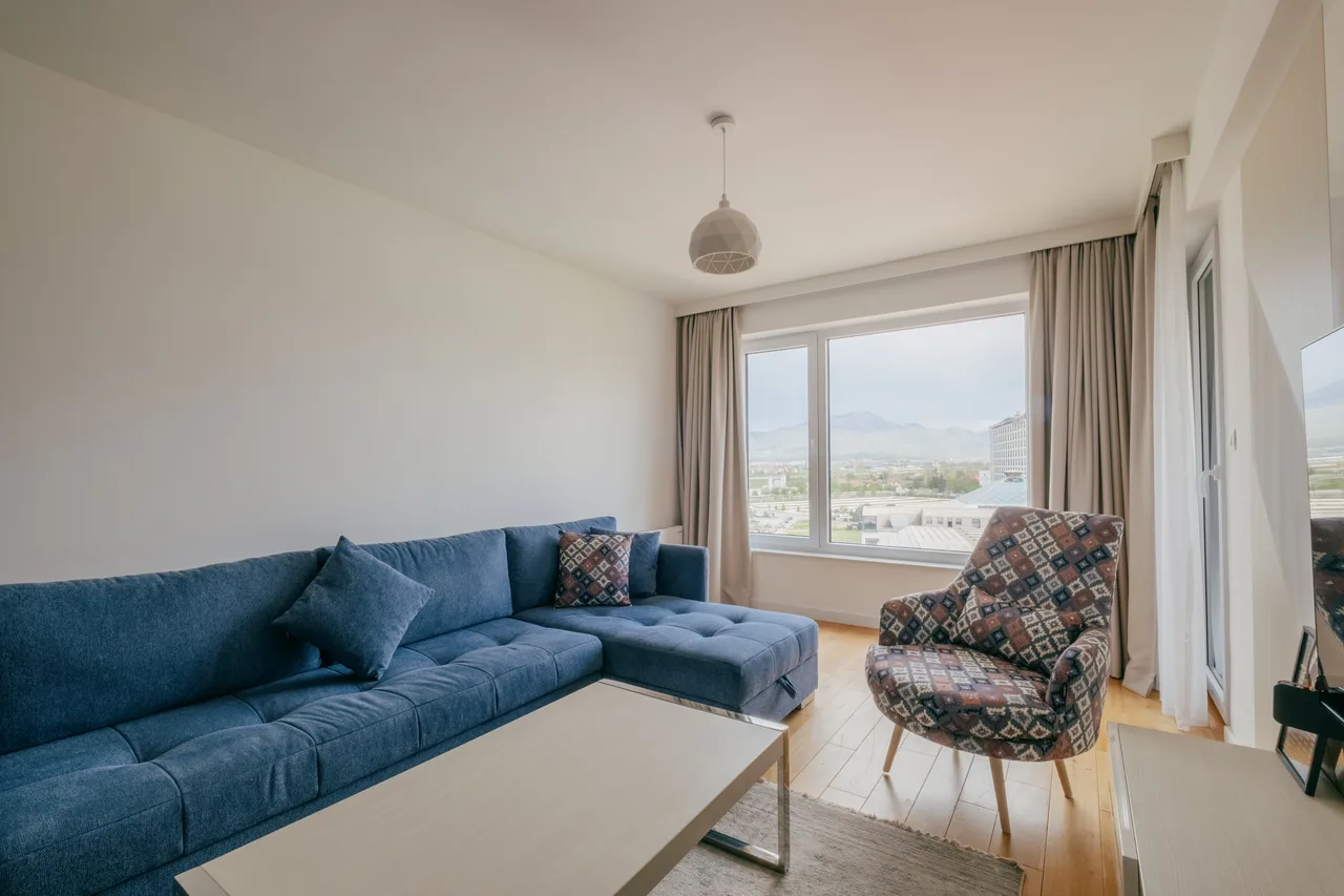 Blue sofa and grey kitchen in a two-bedroom apartment